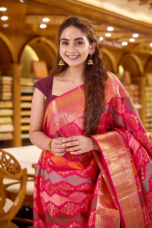 Red pink dual shade Rankat Kanchipuram Samudrika Silk Saree adorned with 5 colour silk thread and golden zari wave motifs, finished with a traditional arumbu malligai mayilkan border, rich arai madam lotus pallu, and a matching self plain blouse.