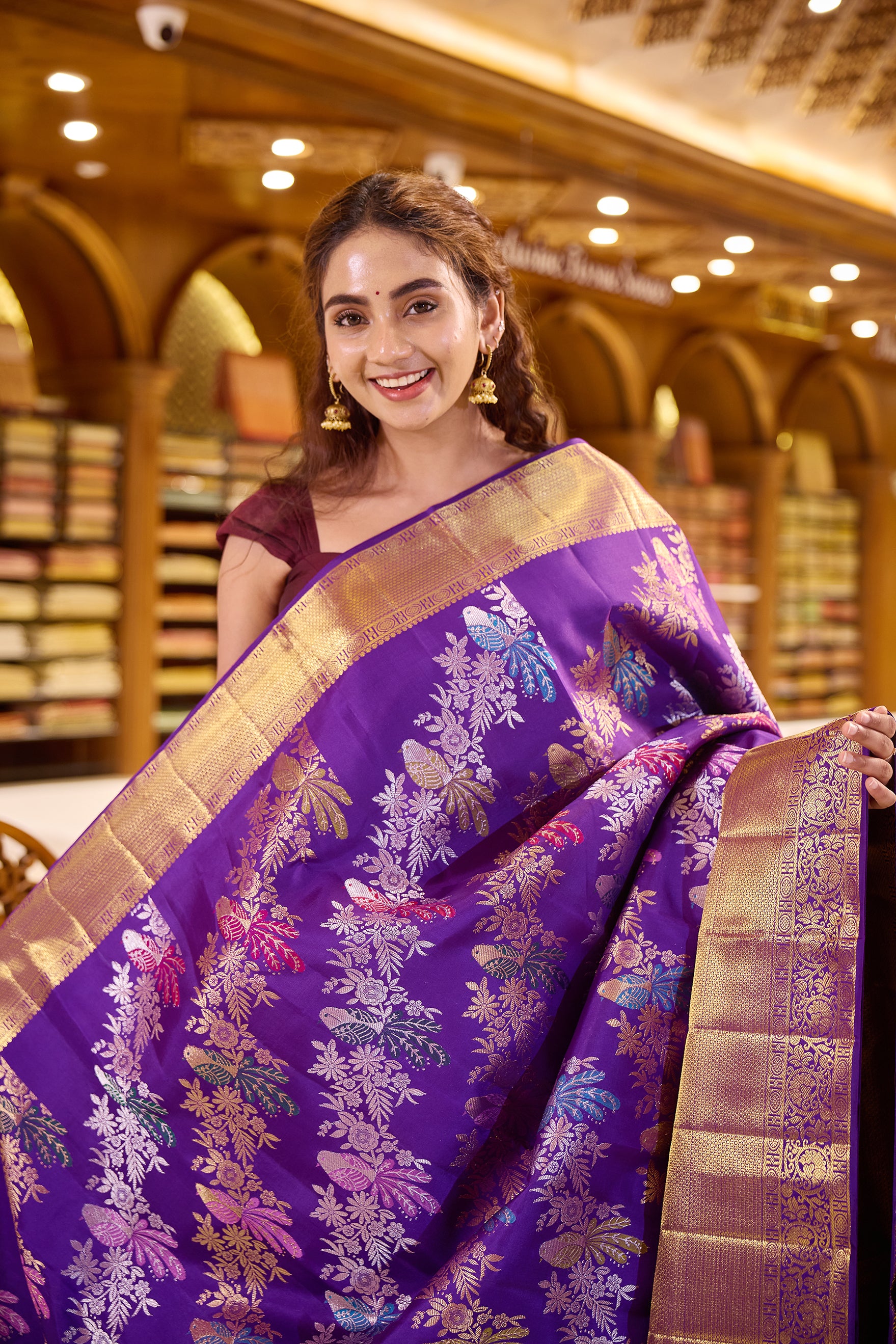 Royal purple colour Renkath Kancheepuram Samudrika Silk Saree with rich gold zari jacquard featuring intricate floral and bird motifs, complemented by a traditional zari border and paired with a matching blouse piece.