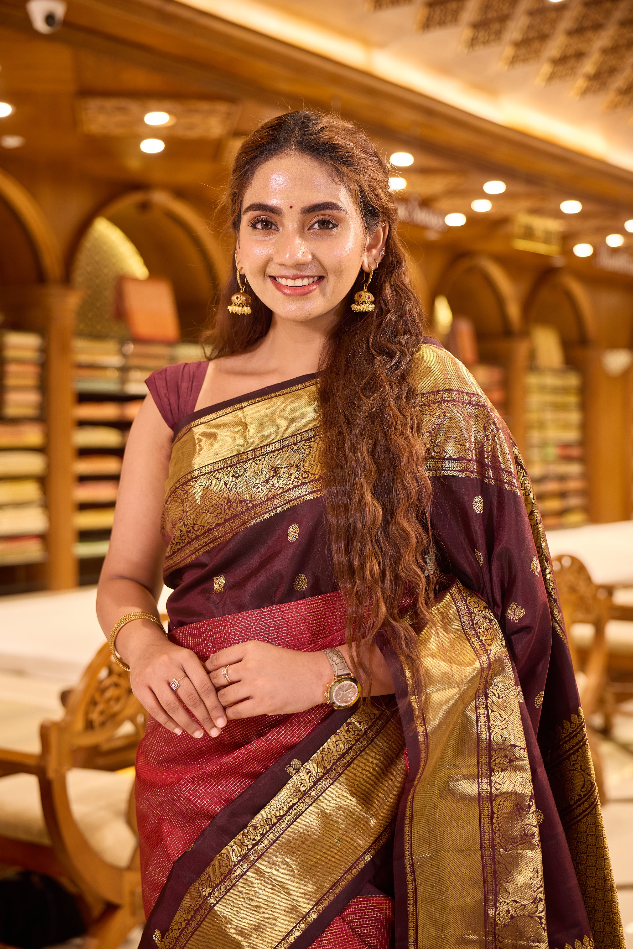 Maroon & Brown Shade Kanchipuram Traditional Handloom Silk Saree featuring vaira oosi zari checks on the body with contrasting Mayuri chakra motifs woven in rich antique gold zari, elegantly finished with a classic gold zari border.