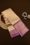 Gold colour tissue brocade saree featuring intricate self weave patterns, complemented by a rich contrast lavender border adorned with delicate paisley and floral zari work, perfect for festive and bridal occasions