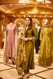 Elegant olive green Anarkali suit with cut bead work on the neckline and intricate thread embroidery on sleeves. Paired with a contrasting dupatta highlighted with a zari border for a refined ethnic look.