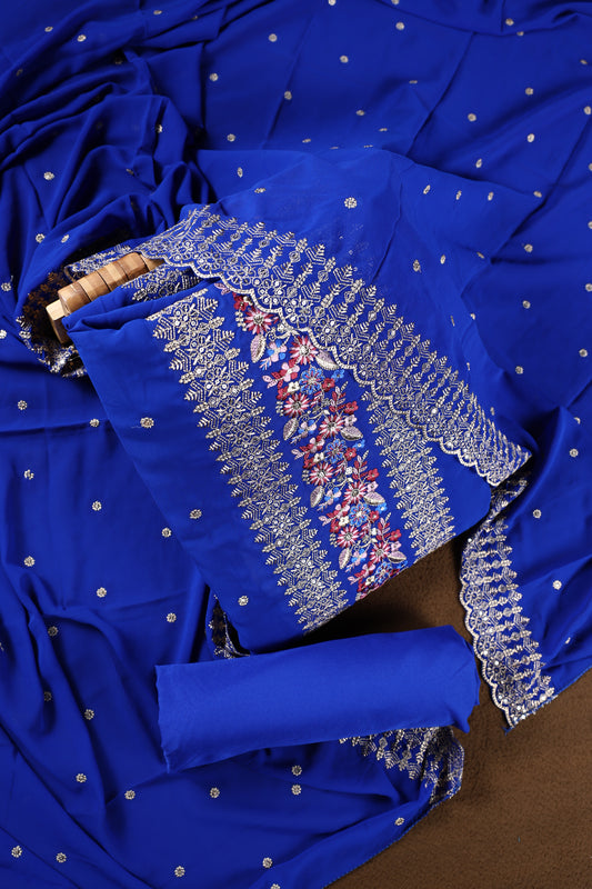 Royal blue colour churidhar material beautifully designed with golden floral embroidery and multicolour thread highlights, paired with a plain matching bottom and an elegant embroidered dupatta.