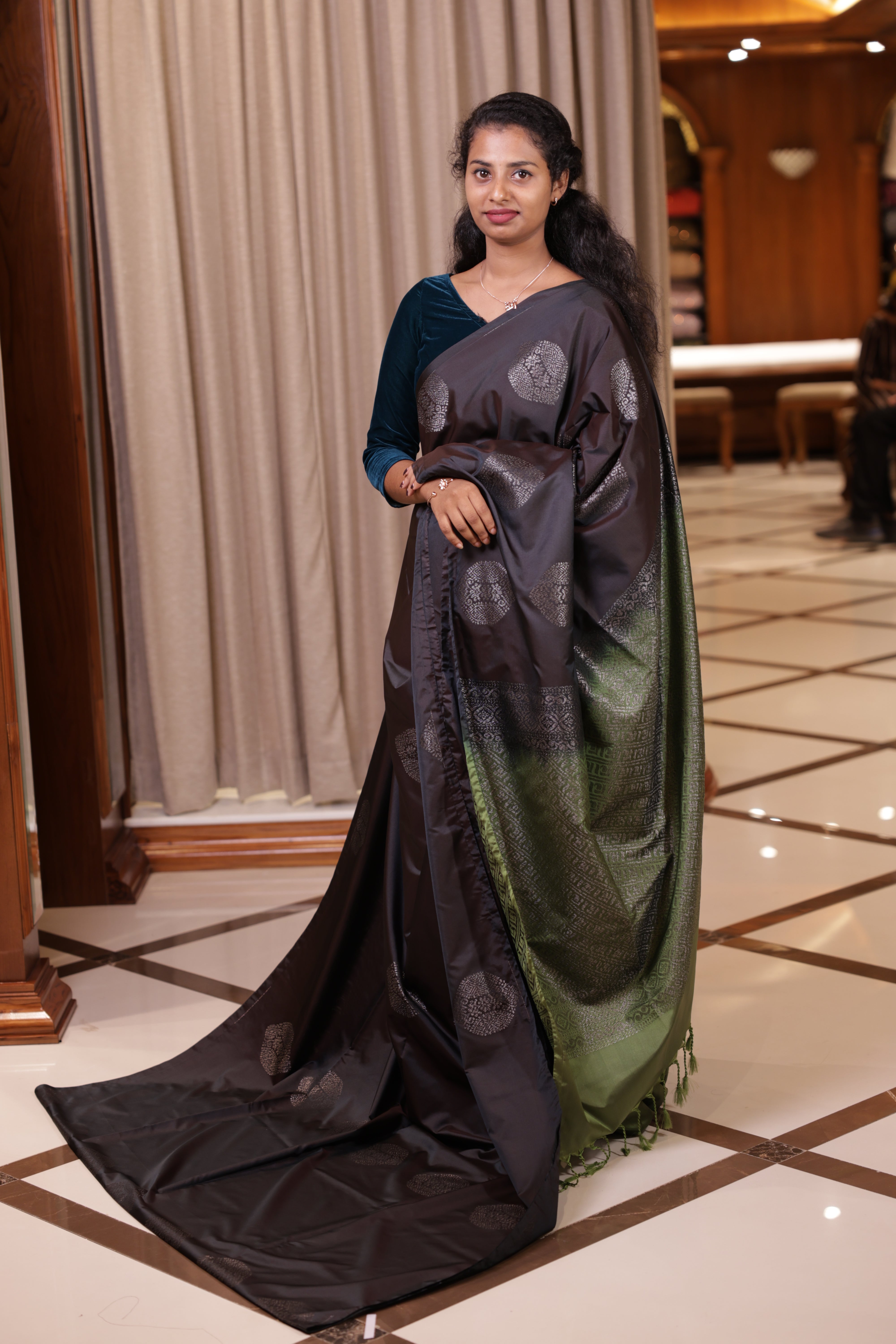 Black colour Soft semi silk Palavarna Pattu saree adorned with metallic zari design in self & contrast patterns, The rich olive green pallu enhances its charm, paired with a matching blouse piece for a graceful traditional look.