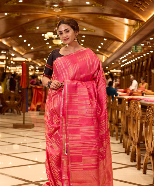 Plush Pink Kanchipuram Parampara Pattu saree featuring elegant diagonal geometric tissue zari line weaving with embossed silk patterns across the body, enhanced by a refined zari piping border and paired with a matching blouse piece.
