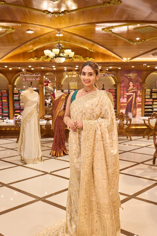 Ivory Colour Satin Banaras Crepe Silk Saree with All woven Traditional Jaal Weave and Silver Meena Motifs, Featuring Hand Beadwork on Pallu and Border, Paired with Matching Blouse Piece.