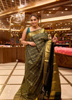 Bottle green colour pure Kancheepuram silk saree featuring gold zari checks all over the body with a gold zari border, complemented by a rich pallu and a matching silk blouse.