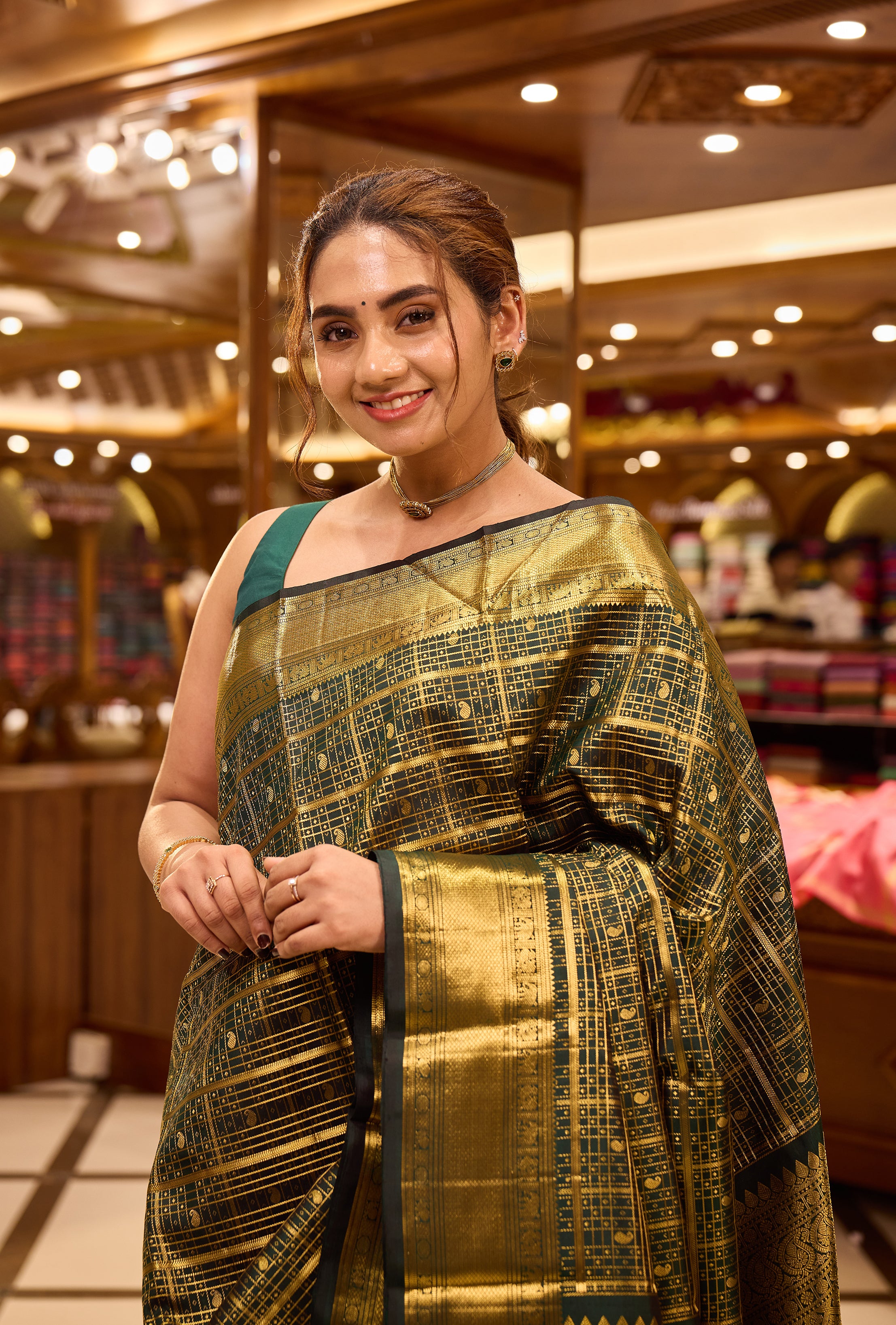 Bottle green colour pure Kancheepuram silk saree featuring gold zari checks all over the body with a gold zari border, complemented by a rich pallu and a matching silk blouse.