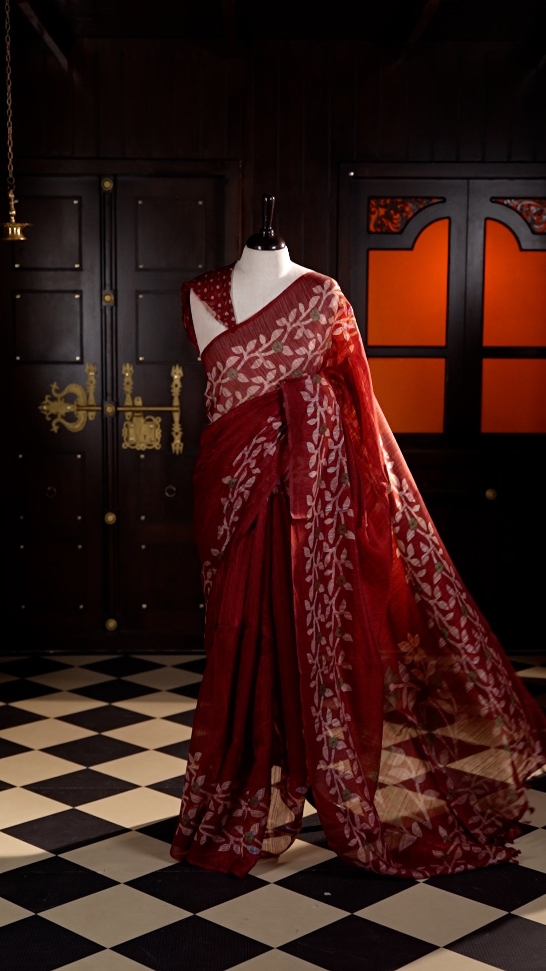 Maroon colour Semi Jute Material saree with leaf print and floral design on body, finished with a floral designed matching blouse.
