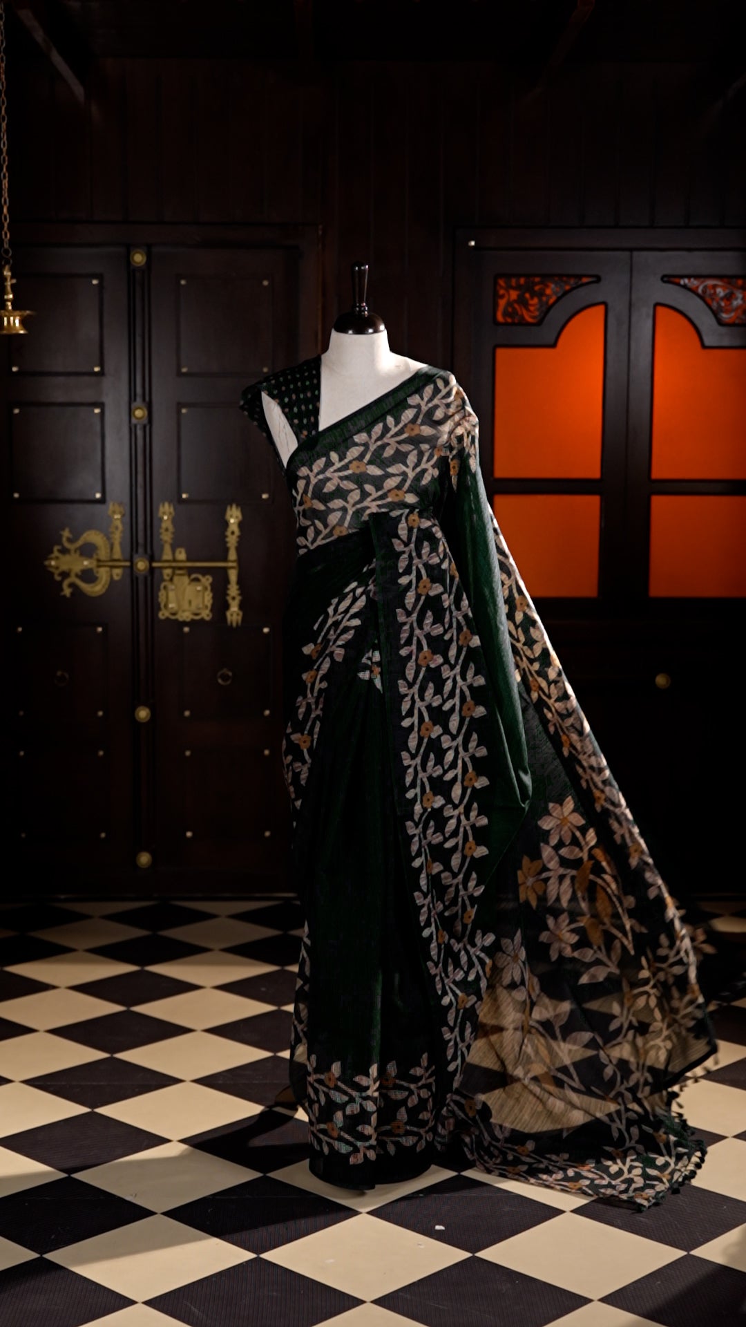Dark Green colour Semi Jute Material saree with leaf print and floral design on body, finished with a floral designed matching blouse.