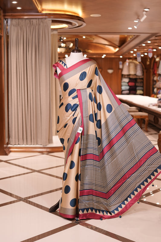 Cream colour semi modal saree featuring bold Teal Blue polka dots and elegant striped detailing, finished with a contrasting Red border and paired with a perfectly matching blouse