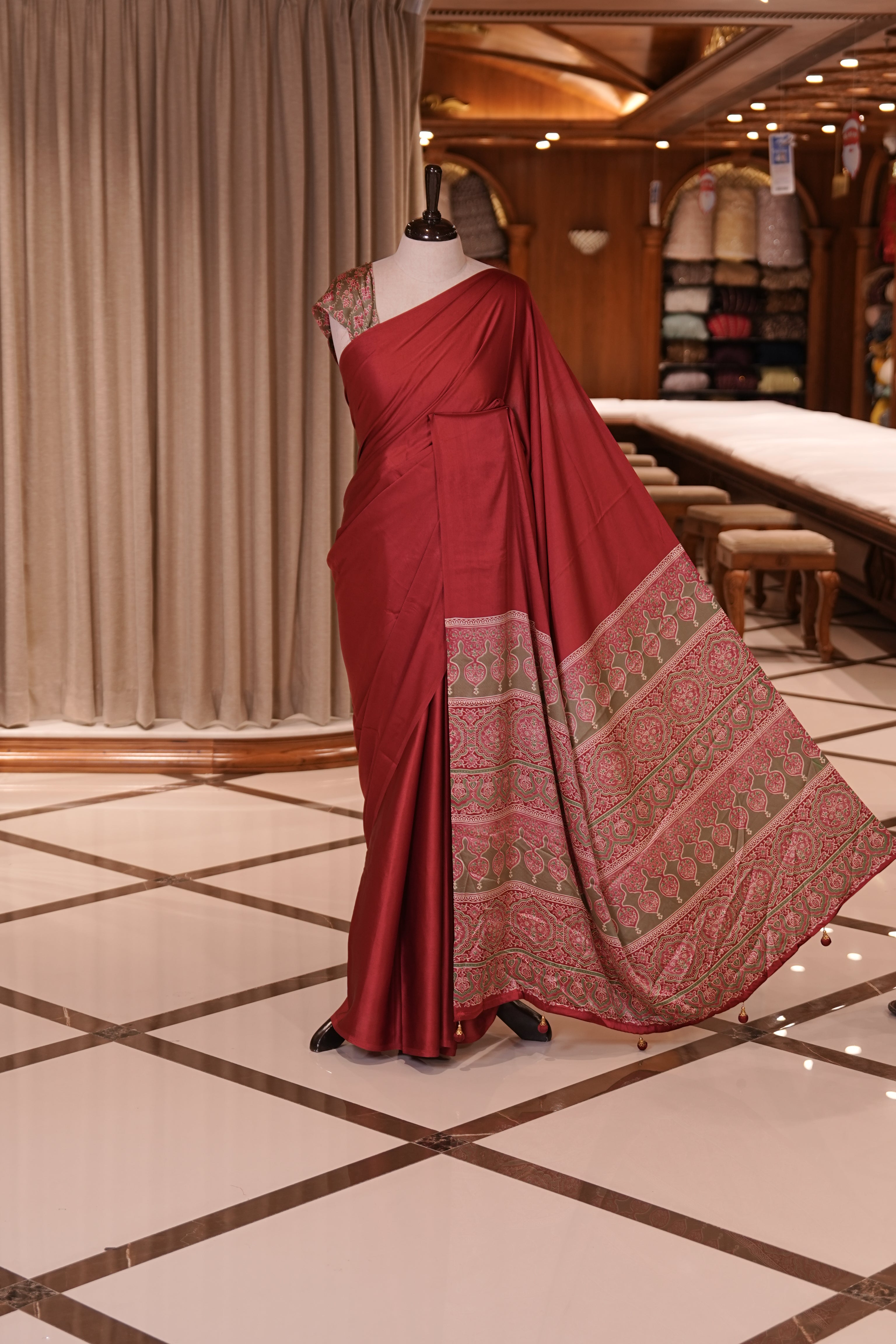Maroon Colour semi modal saree featuring a graceful solid body, beautifully enhanced with an intricately woven contrast Ajrakh printed pallu and a perfectly matching Ajrakh blouse.