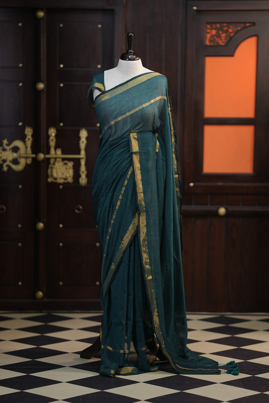 Green colour mul mul cotton saree accentuated by delicate Gold borders and body, paired with a matching blouse.