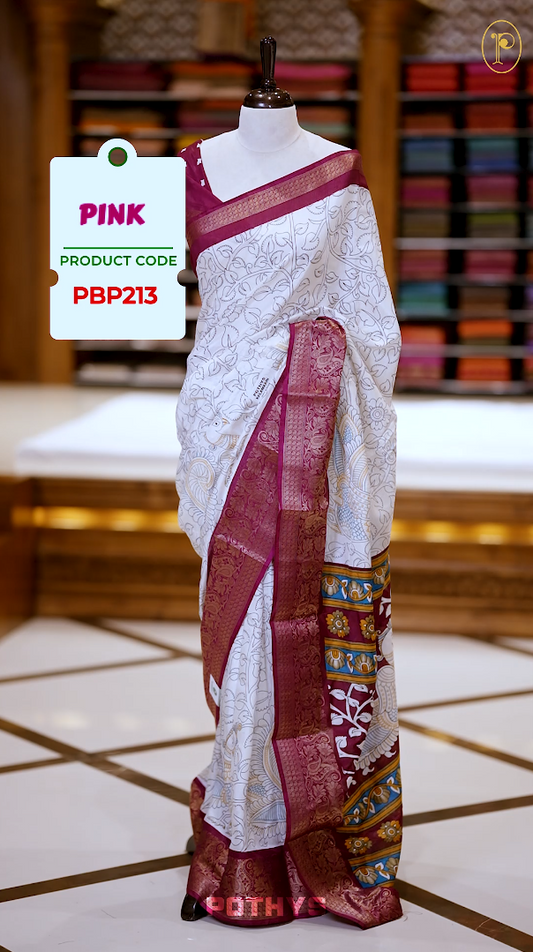 White colour Kalamkari saree featuring intricate prints, paired with a striking pink and golden traditional border & The multicolor Kalamkari printed pallu adds vibrant charm, perfectly matched with a coordinating blouse.