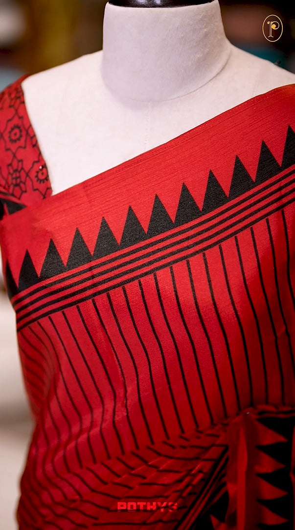 Red semi modal crepe saree featuring black vertical line prints, complemented by a temple border and circle butta design on the pallu, paired with a matching printed blouse.