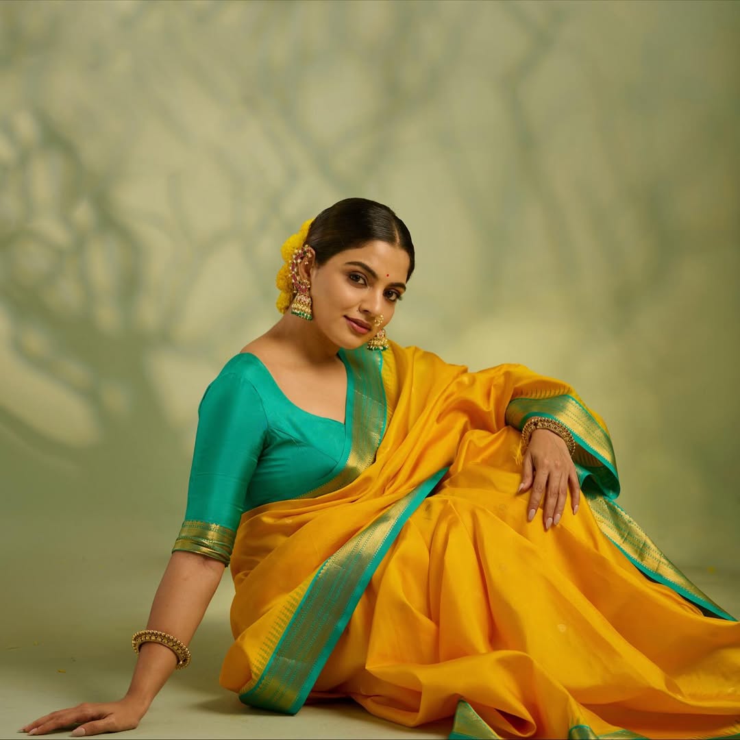 Sunshine yellow colour Kanchipuram Silk saree, featuring intricate gold motifs, a vibrant teal green border, and a grand pallu paired with a matching blouse