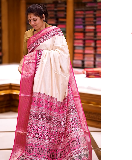 Beige Dolla silk saree featuring antique zari stripes across the body, adorned with a striking Ajrak and Traditional pink colour border, ajrak printed pallu and paired with a perfectly matching blouse.