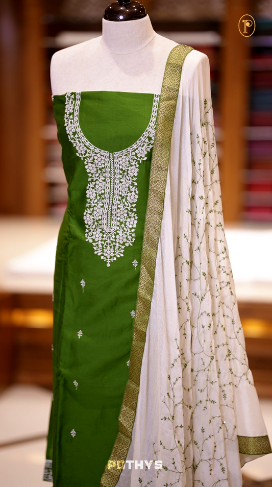 Green colour semi silk salwar set highlighted with intricate white chikankari embroidery on the neckline and body, paired with matching bottom and contrasting ivory dupatta.