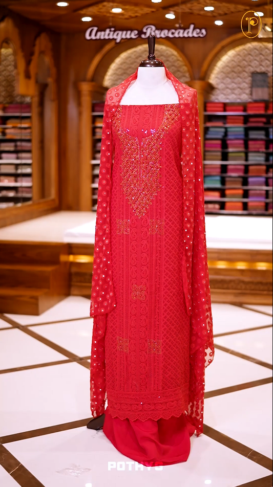 Red colour georgette partywear churidhar material featuring intricate stone and beadwork on the top, paired with a plain bottom and a mirror worked dupatta.