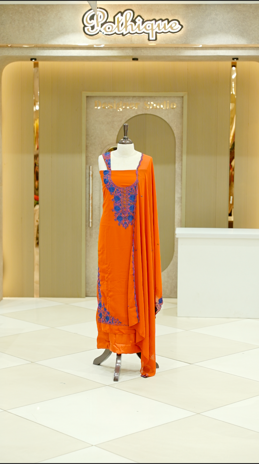 Orange colour georgette salwar suit material featuring intricate Blue floral thread embroidery on the neckline and side opening, complemented with a matching bottom and dupatta. Comes with lining included for added comfort and finish.