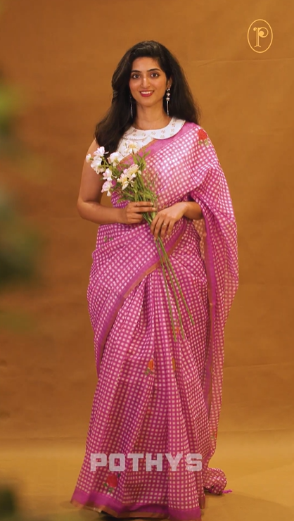 Purple colour Semi Linen saree featuring a stylish check pattern adorned with floral prints on the body, enhanced by a small gold border, paired with a matching blouse piece.