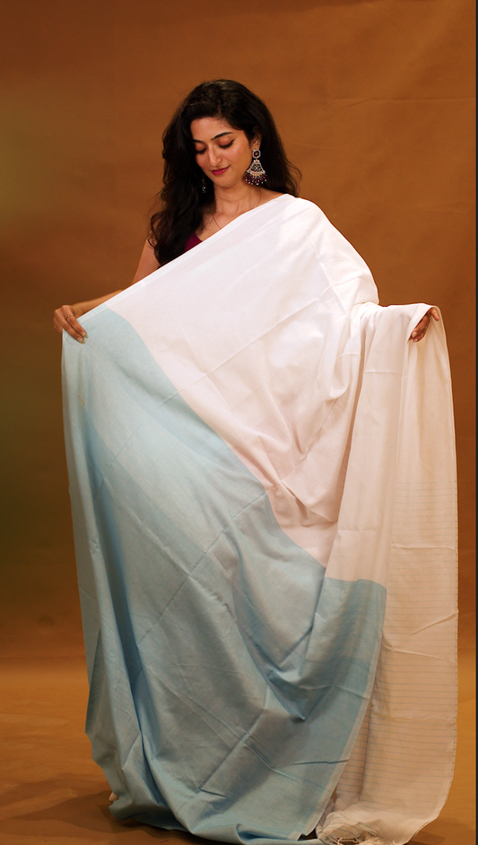 Blue colour Mul Cotton saree featuring a half and half patterned body, highlighted by a contrast border and striped pallu, paired with a matching blouse piece.