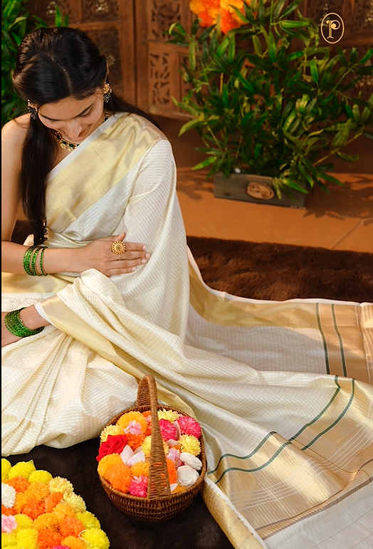 Cream colour Semi Soft Silk saree Featuring Gold zari check Pattern on body, complemented by Double side Bavanchi Border with striped pallu, Comes with Running blouse With multi colour Buttas.