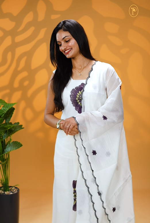 White Colour Mul Chanderi Salwar Material Featuring Purple Colour Floral Thread Work on body, paired with matching santoon Material Bottom & Floral thread Worked motifs And Scallop Embroidery Black Border Dupatta.