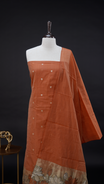 Rust Orange Semi chanderi salwar material featuring Gold small Buttas on body, Daman borderi with lotus Design, same pattern dupatta, santoon bottom.