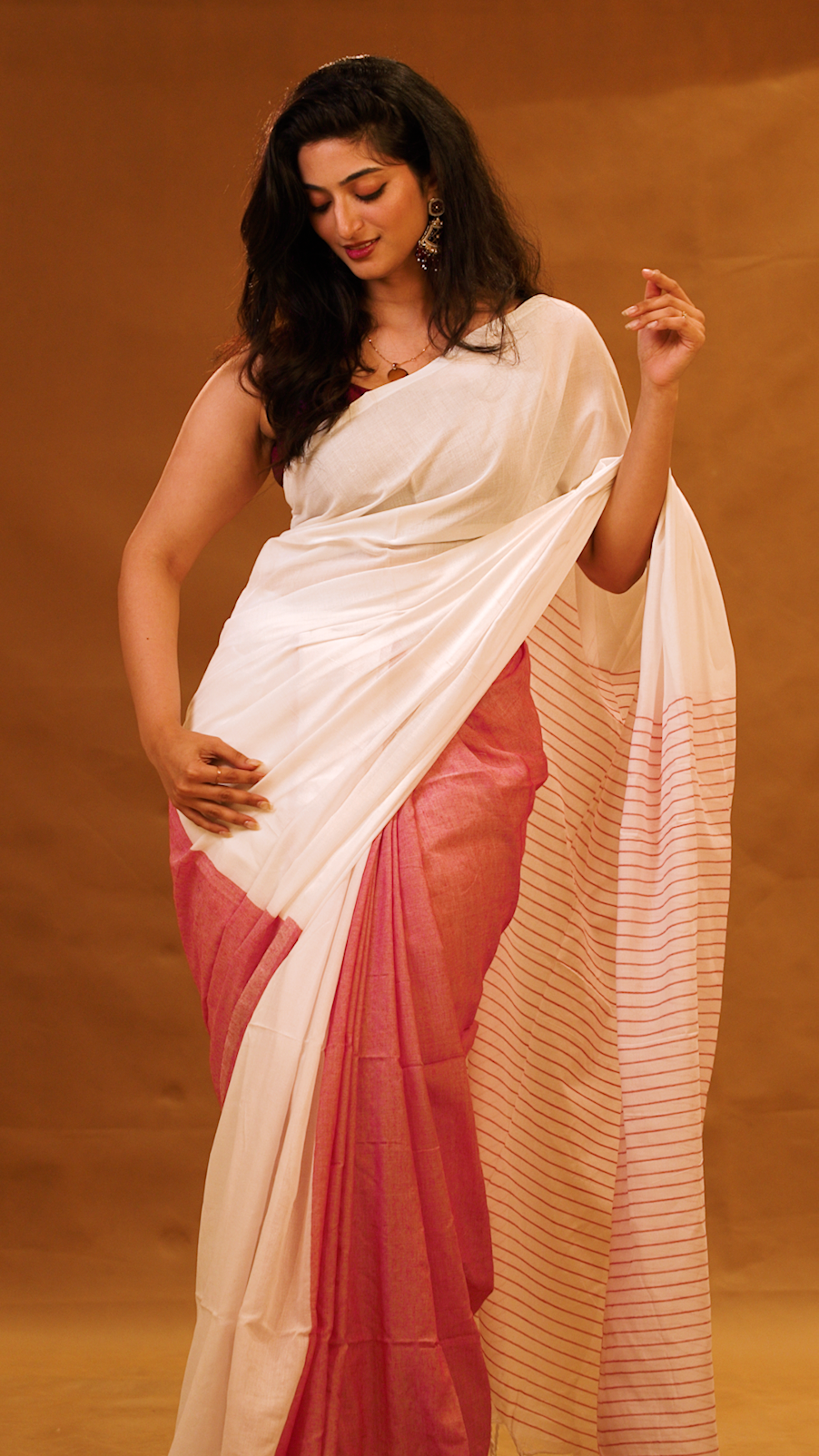 Red colour Mul Cotton saree featuring a half and half patterned body, highlighted by a contrast border and striped pallu, paired with a matching blouse piece.