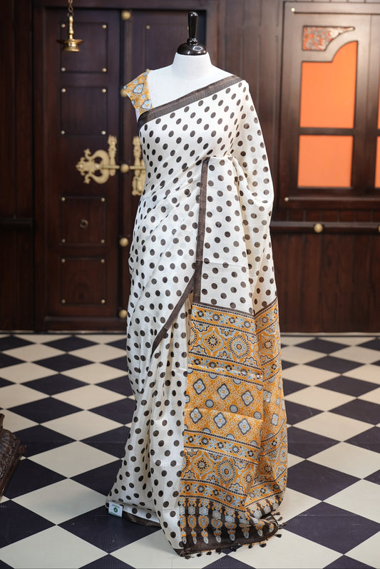 Coffee Brown with Mustard Yellow colour Semi Khadi Silk Material saree with full polka dots body, finished with a ajrakh print blouse and pallu, paired with a matching blouse.