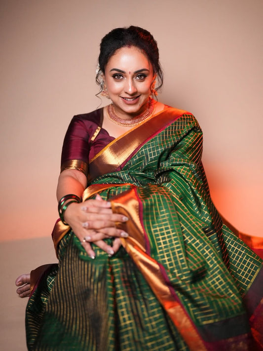 Bottle green and maroon Kancheepuram silk saree adorned with zari checks on the body, traditional bavanji border, mustard-maroon edge piping, and a contrasting jacquard zari pallu, paired with a matching maroon blouse