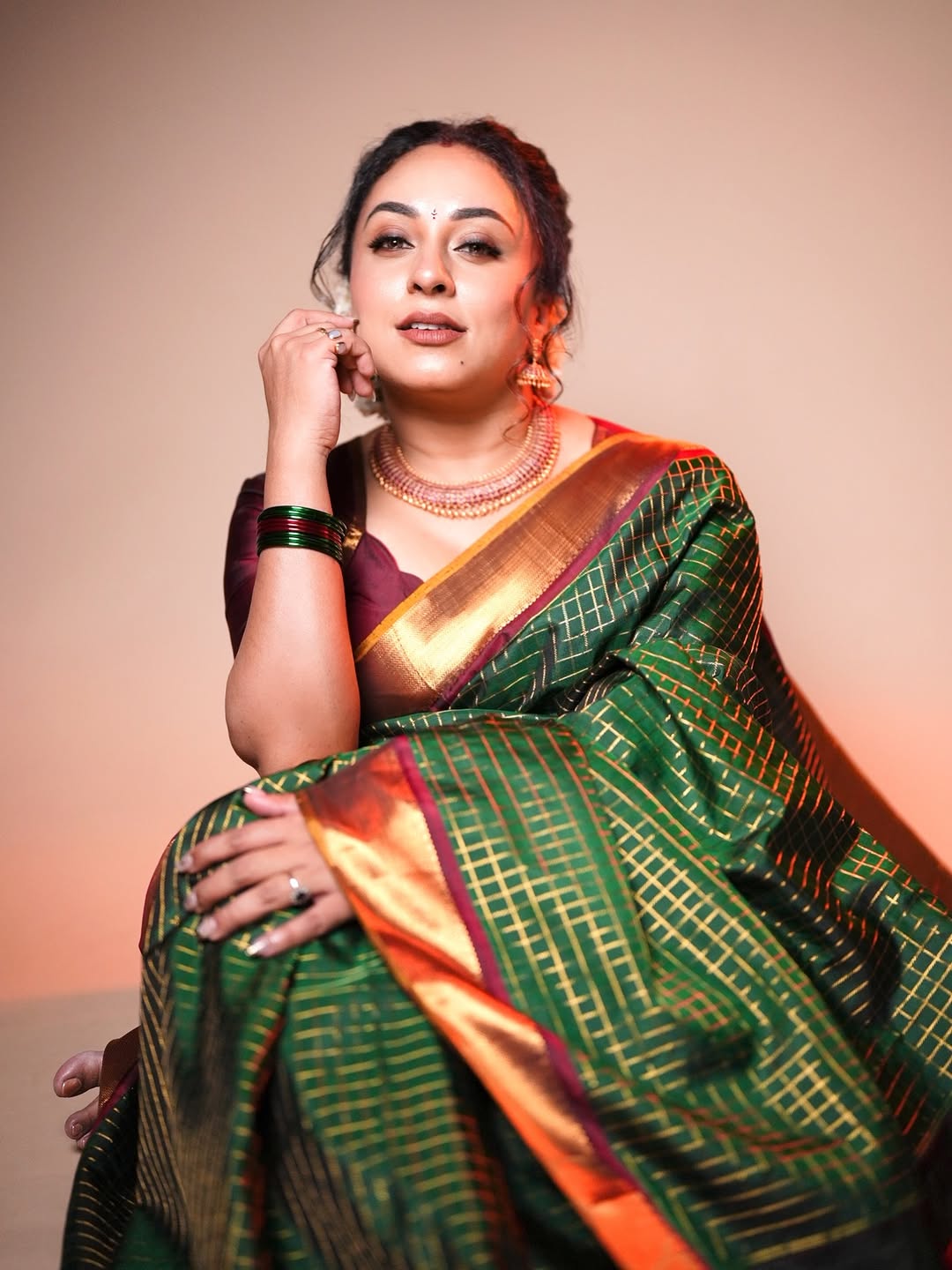 Bottle green and maroon Kancheepuram silk saree adorned with zari checks on the body, traditional bavanji border, mustard-maroon edge piping, and a contrasting jacquard zari pallu, paired with a matching maroon blouse