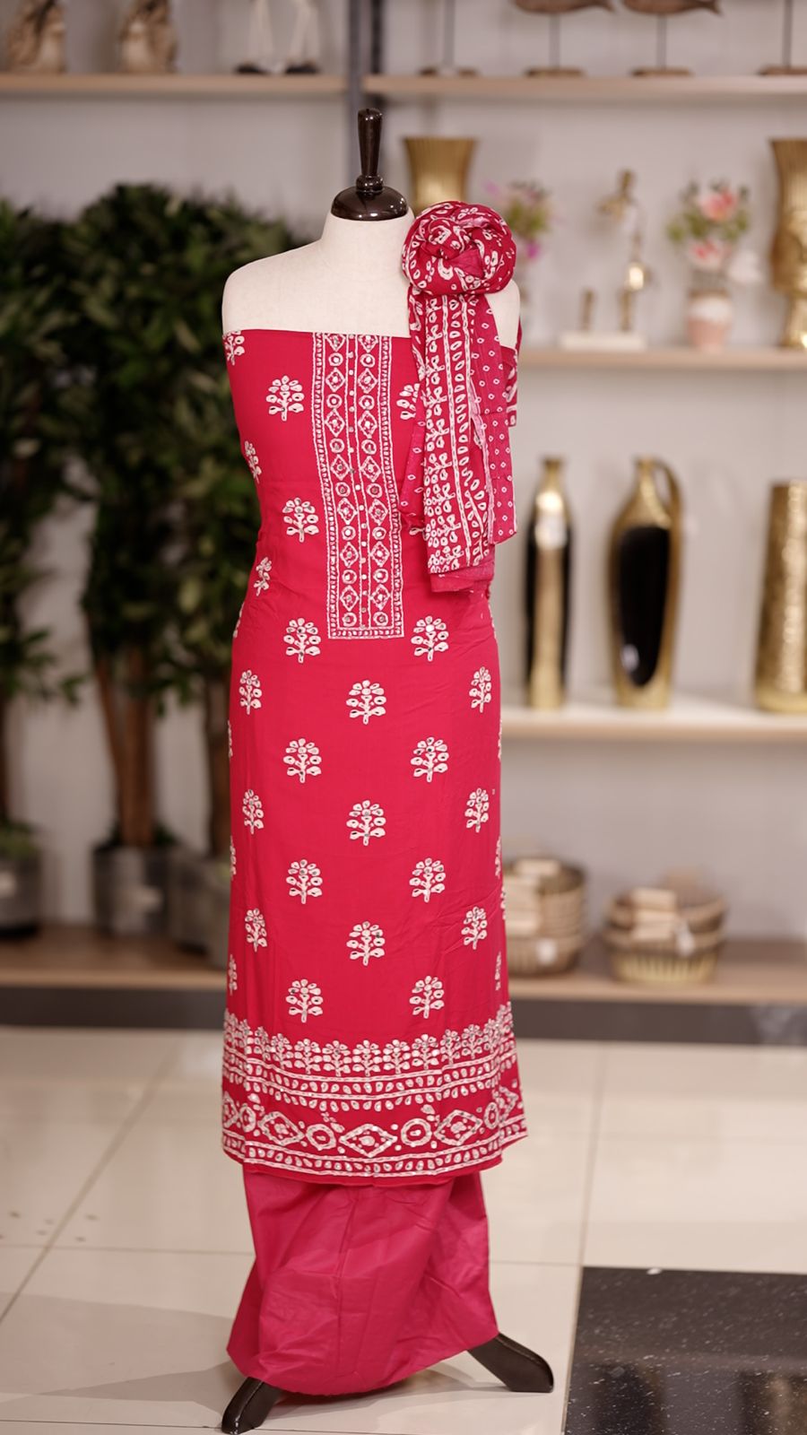 Deep pink colour cotton churidhar material featuring floral prints with delicate mirror design on the top, paired with a matching bottom and printed dupatta
