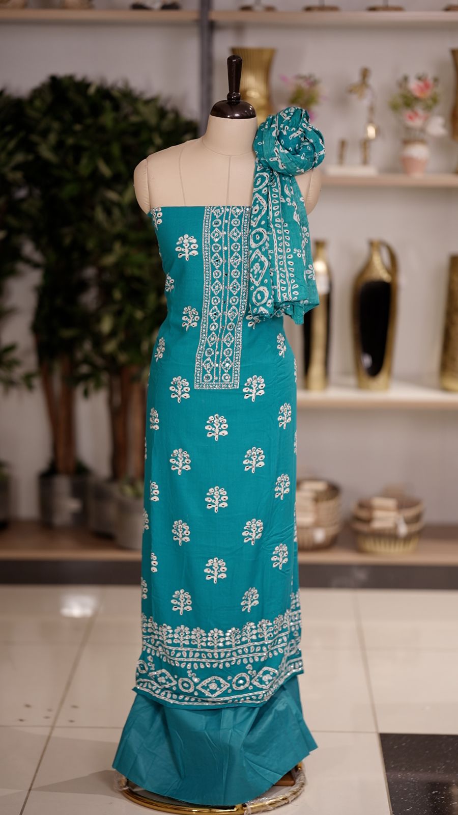 Teal Blue colour cotton churidhar material featuring floral prints with delicate mirror design on the top, paired with a matching bottom and printed dupatta