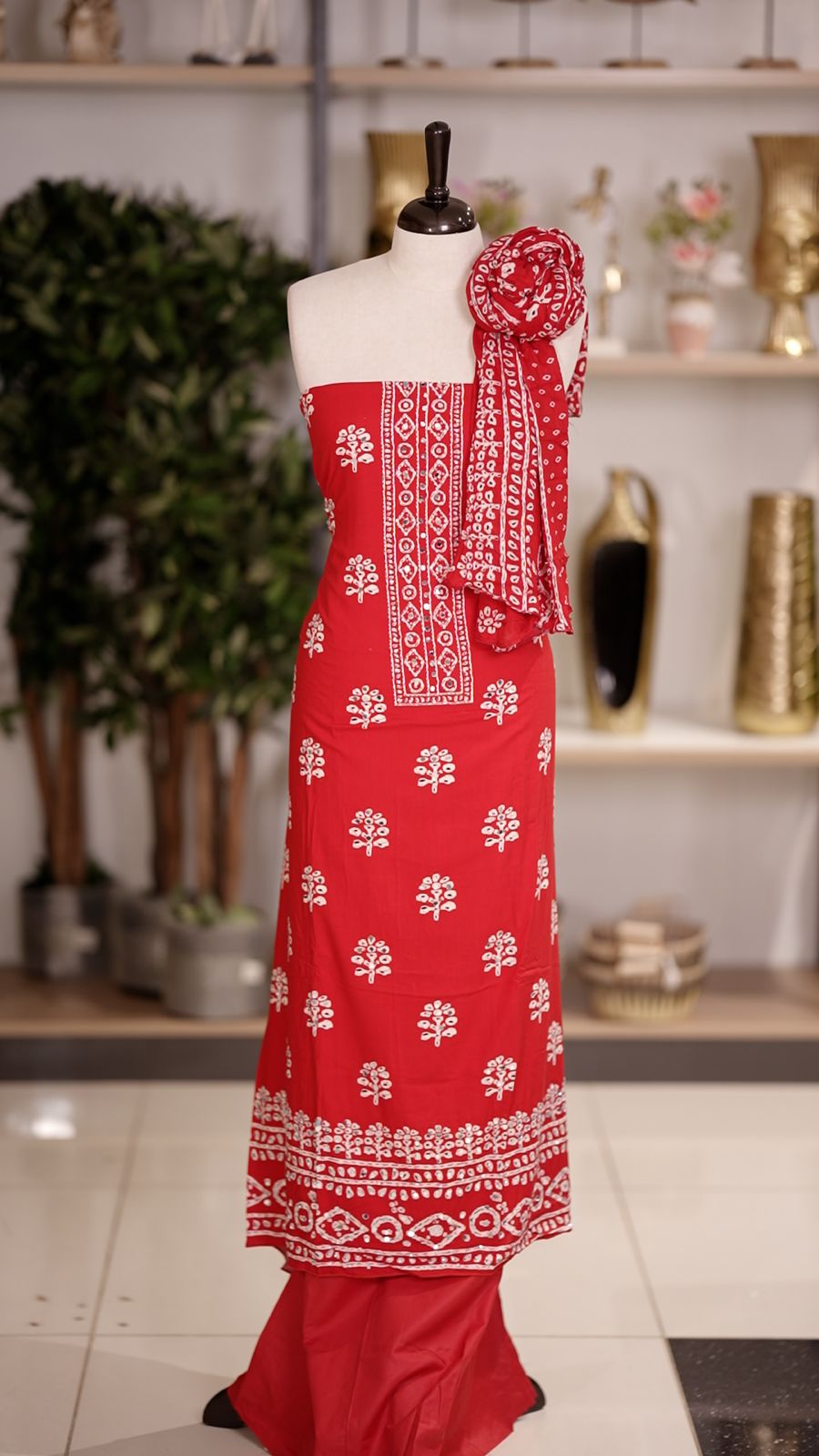 Brignt Red colour cotton churidhar material featuring floral prints with delicate mirror design on the top, paired with a matching bottom and printed dupatta
