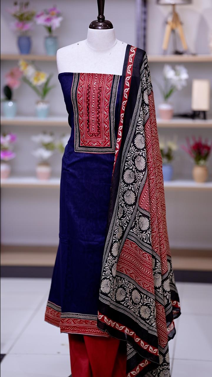 Navy blue colour cotton salwar suit with deep red yoke featuring subtle sequin work on the neckline, Paired with a plain bottom and a printed cotton dupatta, this set blends comfort with traditional elegance.