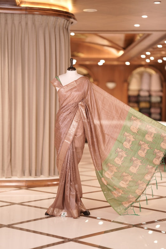 Mauve & green colour Dolla silk saree featuring a striped body with a matching golden zari border, The pallu showcases exquisite Kalamkari prints, complemented by a contrast printed blouse.