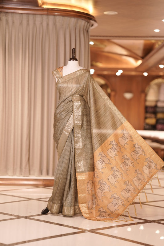 Olive green & yellow colour Dolla silk saree featuring a striped body with a matching golden zari border, The pallu showcases exquisite Kalamkari prints, complemented by a contrast printed blouse.
