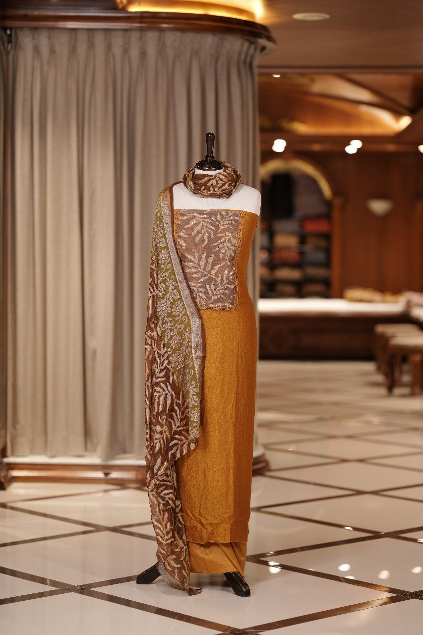 Mustard Yellow colour Vichithra silk Salwar suit featuring rich Leaf design & Mirror worked neckline, Chiffon printed dupatta & paired with a plain bottom.