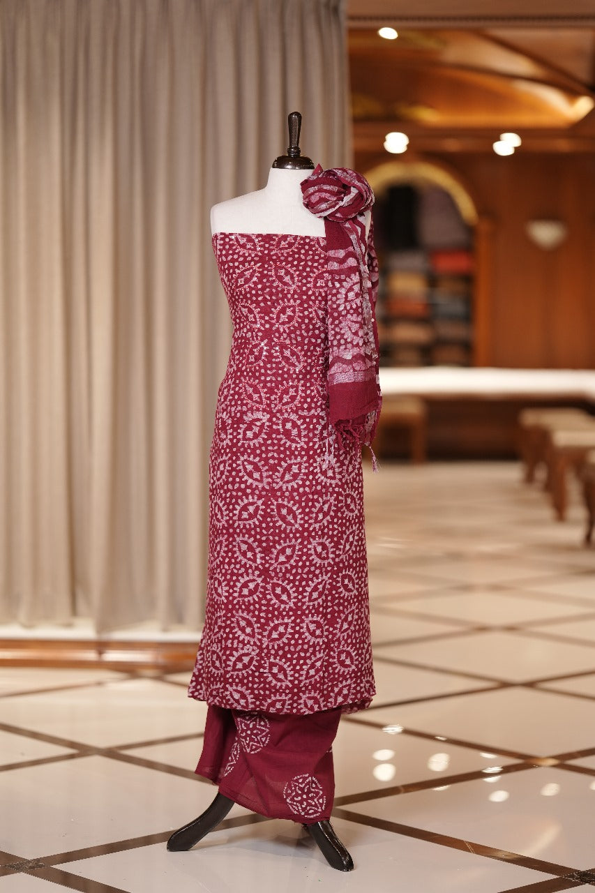 Maroon colour semi linen fabric featuring batik prints enhanced with thread and sequin work, paired with a side printed dupatta and a block printed bottom