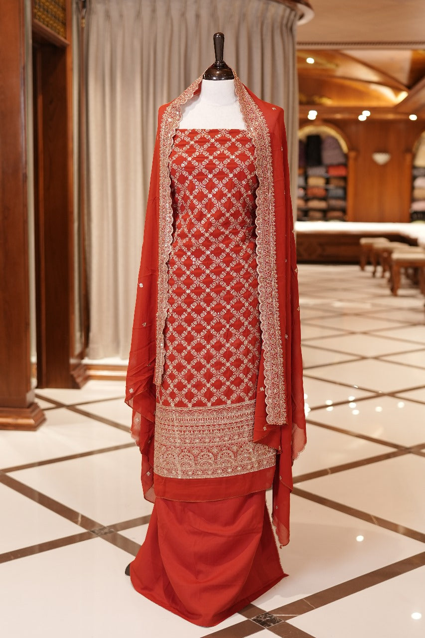 Orange Colour Georgette top adorned with gold zari and sequin work, paired with a scallop bordered dupatta featuring golden zari embroidery and a plain bottom.