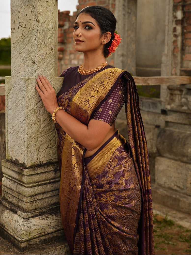 Dark purple colour Samudrika Pattu saree featuring traditional Kodi Malar motifs with peacock, elephant, and simham zari weaving, complemented by an elegant Annam zari pettu border and paired with a matching blouse piece.
