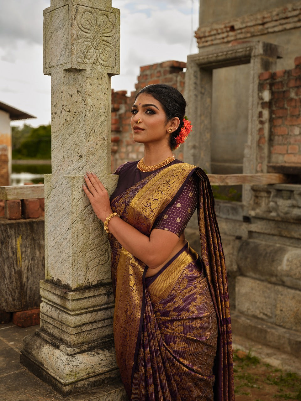 Dark purple colour Samudrika Pattu saree featuring traditional Kodi Malar motifs with peacock, elephant, and simham zari weaving, complemented by an elegant Annam zari pettu border and paired with a matching blouse piece.