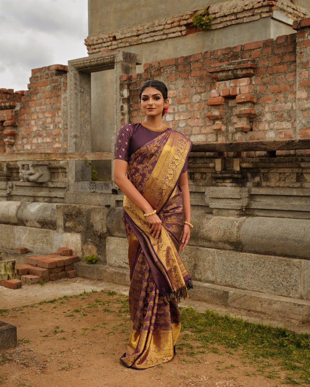Dark purple colour Samudrika Pattu saree featuring traditional Kodi Malar motifs with peacock, elephant, and simham zari weaving, complemented by an elegant Annam zari pettu border and paired with a matching blouse piece.