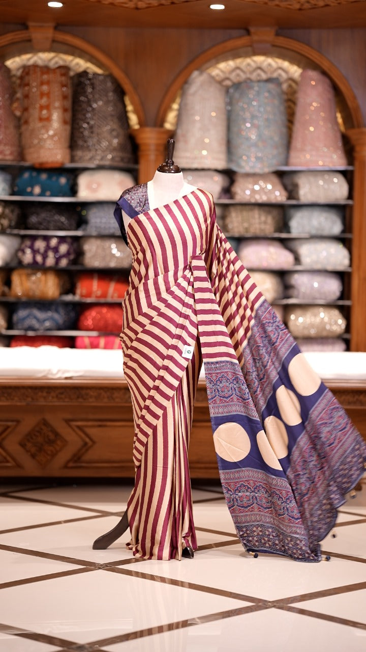 Cream and Maroon striped Semi modal silk saree highlighted with a rich pallu featuring artistic motifs, paired with a matching blouse