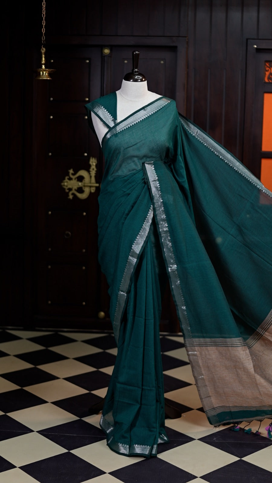 Sapphire Green colour saree with a soft, airy drape, accentuated by delicate silver woven borders and a subtle striped pallu, paired with a matching blouse.