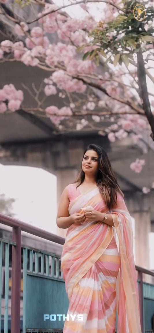 Pastel pink, yellow & white mul mul cotton saree accentuated by delicate gold borders and a subtle striped body, paired with a matching blouse piece.