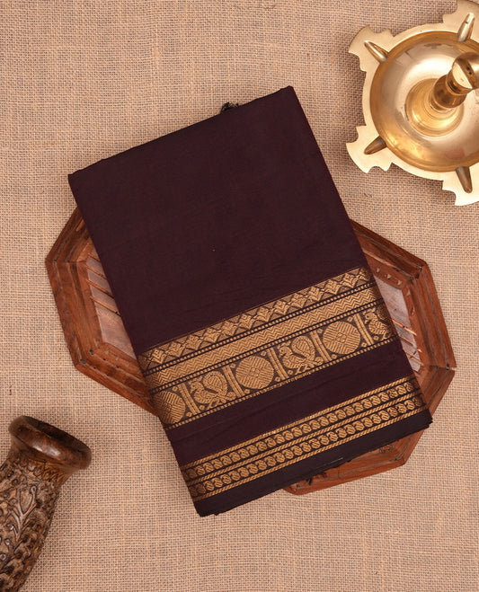 Dark chocolate colour Chettinad cotton saree with a plain body, featuring a traditional border and pallu with gold zari detailing, paired with a matching blouse piece.