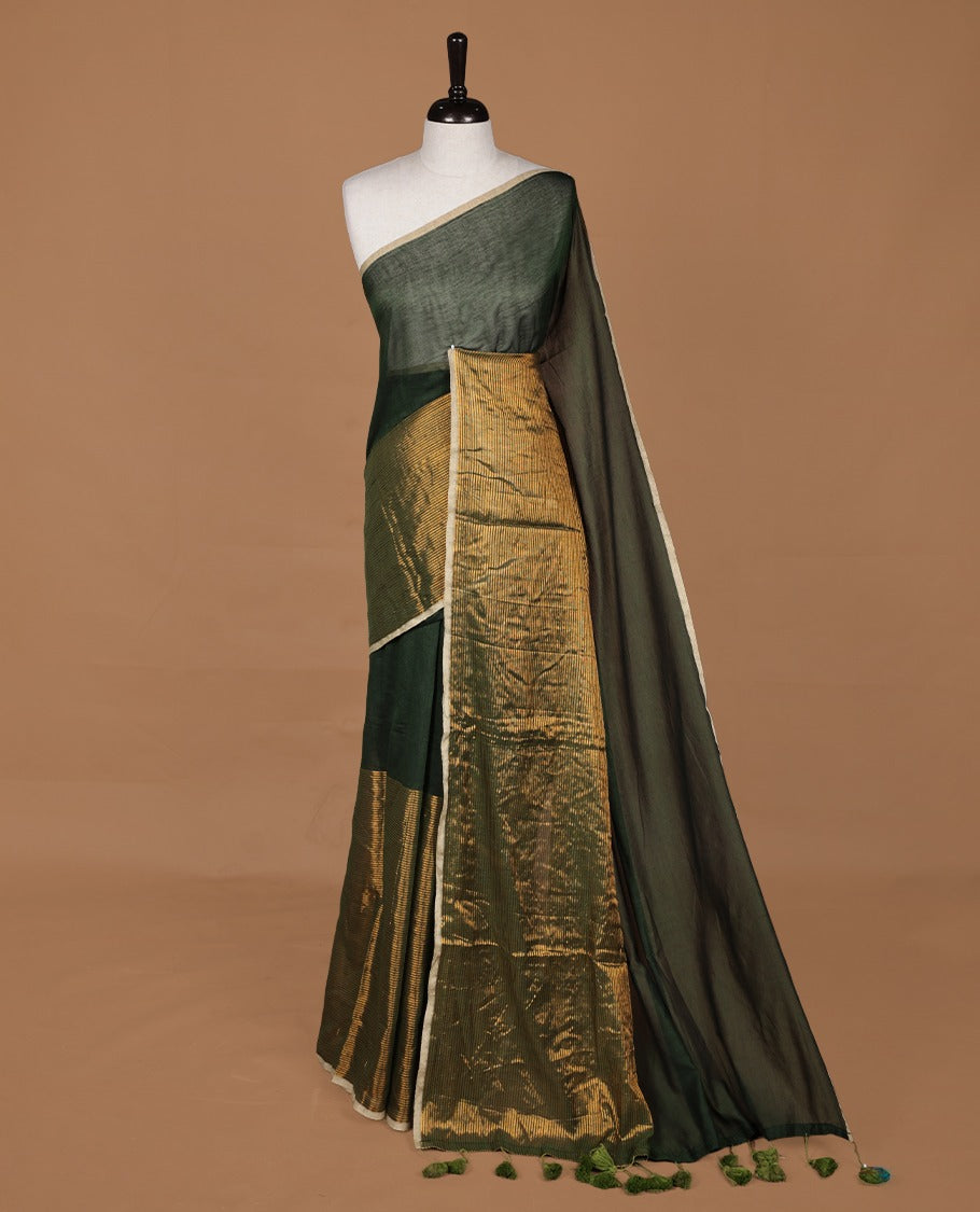 Dark green mul cotton saree with an elegant half and half design, blending plain fabric with a contrasting tissue finish, without blouse piece.