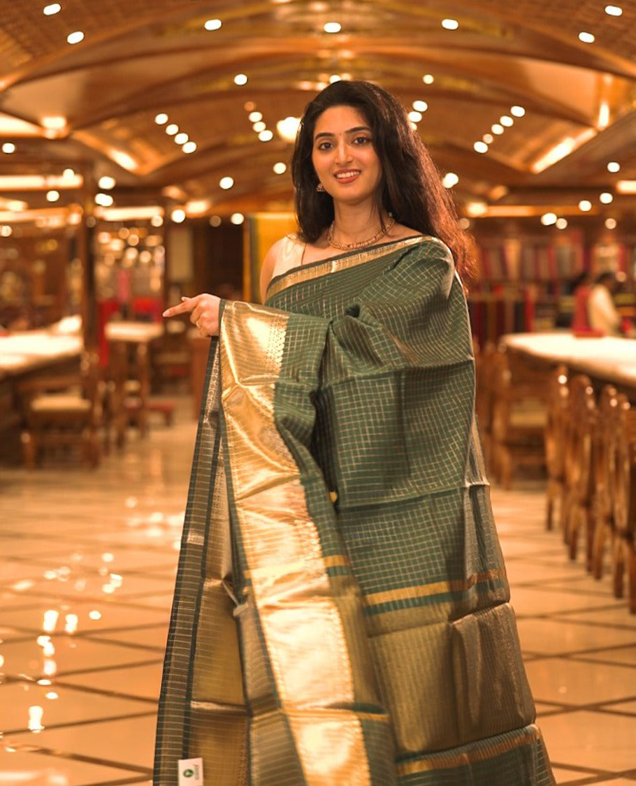 Bottle Green colour semi banaras lichi silk saree featuring checked patterned body, complemented by gold zari border, paired with matching blouse piece.